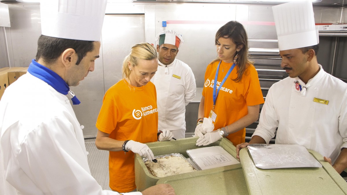 I volontari nelle cucine di bordo verificano il correttu confezionamento del cibo