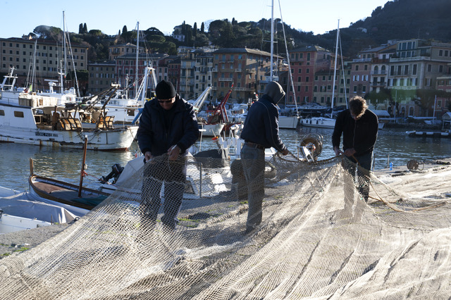 i pescatori riparano le reti nei momenti di fermo 
